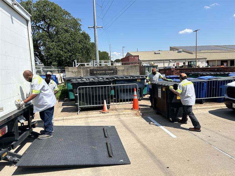 Milton Roberson Jr. (left), SWR team lead, and Tim Williams, an SWR worker, stand under the Darrell K Royal-Texas Memorial Stadium’s north loading docks, preparing for the next load of trash after a home football game. SWR crews work post-game Saturday and return on Sunday to complete the removal of all waste.